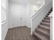 Inviting entryway features neutral walls, wood-look floors, a white door and staircase with carpeted treads at 558 Orient Ave, Debary, FL 32713