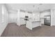 Spacious kitchen boasts stainless appliances, white cabinets, a center island, and hard surface floors at 558 Orient Ave, Debary, FL 32713