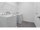 Laundry room with white washer and dryer, wire shelving and gray tile floor at 558 Orient Ave, Debary, FL 32713