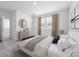 Bright main bedroom boasts natural light from the window, neutral paint and carpet, and a decorative dresser at 558 Orient Ave, Debary, FL 32713