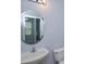 Neutral bathroom featuring a stylish round mirror over a sink and toilet area at 5843 Strada Capri Way, Orlando, FL 32835