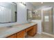 Bathroom featuring double sinks, wood cabinets, and a glass-enclosed shower area at 5843 Strada Capri Way, Orlando, FL 32835