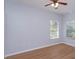 Neutral bedroom with light wood flooring, and ample natural light from dual windows at 5843 Strada Capri Way, Orlando, FL 32835