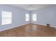 This bedroom is naturally lit, with three windows and lovely wood look flooring at 5843 Strada Capri Way, Orlando, FL 32835