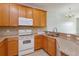 Well-lit kitchen showcasing wood cabinets, granite countertops, and modern appliances at 5843 Strada Capri Way, Orlando, FL 32835