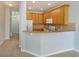 Open-concept kitchen featuring wood cabinets, granite countertops, and a breakfast bar overlooking living area at 5843 Strada Capri Way, Orlando, FL 32835