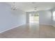 Bright and spacious living room featuring tile floors, a chandelier, ceiling fan, and sliding glass doors to backyard at 5843 Strada Capri Way, Orlando, FL 32835