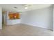 Bright, open living area with tile flooring flowing into kitchen with light wood cabinetry and chandelier lighting at 5843 Strada Capri Way, Orlando, FL 32835