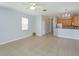 Spacious living room with tile flooring, ceiling fan, view of open-concept kitchen, and abundant natural light at 5843 Strada Capri Way, Orlando, FL 32835