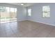 Bright living room featuring tile floors, a ceiling fan, and sliding glass doors to a screened patio at 5843 Strada Capri Way, Orlando, FL 32835