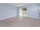 Bright living room featuring tile floors, ceiling fan, and sliding glass doors to the backyard at 5843 Strada Capri Way, Orlando, FL 32835