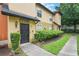 Townhome with a well-manicured lawn and landscaping, black door, and walkway to the home at 6001 Westgate Dr # 2124, Orlando, FL 32835