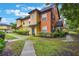 Townhome with colorful stucco exterior, sidewalk, green grass, and lush landscaping on a sunny day at 6001 Westgate Dr # 2124, Orlando, FL 32835