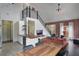 Open-concept living space with kitchen island, dining table, sofa, exposed brick, and modern staircase at 6001 Westgate Dr # 2124, Orlando, FL 32835