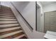 Staircase featuring wooden steps, a white base, and a black handrail at 6001 Westgate Dr # 2124, Orlando, FL 32835