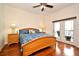 Comfortable bedroom with wood floors, featuring a bed with floral bedding and access to a balcony at 630 Vassar St # 2508, Orlando, FL 32804