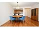 Dining area with a round table and blue chairs adjacent to an open kitchen, featuring hardwood floors at 630 Vassar St # 2508, Orlando, FL 32804