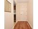 Hallway with wood floors leading to a door, with a glimpse of stainless steel appliances in the nearby kitchen at 630 Vassar St # 2508, Orlando, FL 32804