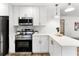 Well-lit modern kitchen with white cabinets, stainless steel appliances, and updated lighting at 7440 Houston E Ct, Winter Park, FL 32792