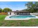 Backyard view showcasing the sparkling pool, the home's exterior, and well-maintained lawn at 7440 Houston E Ct, Winter Park, FL 32792