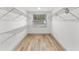Spacious walk-in closet featuring ample shelving, light wood flooring, and natural light at 7440 Houston E Ct, Winter Park, FL 32792