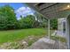 The backyard features a luscious green lawn and mature trees seen from under a shaded patio at 7449 Daniel Webster Dr # 3, Winter Park, FL 32792