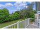 View of a lush green backyard from the balcony with a white railing at 7449 Daniel Webster Dr # 3, Winter Park, FL 32792