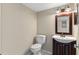 A cozy bathroom featuring a white toilet and vanity with decorative mirror and lighting at 7449 Daniel Webster Dr # 3, Winter Park, FL 32792
