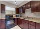 Kitchen featuring dark cabinetry, black appliances and granite countertops at 7449 Daniel Webster Dr # 3, Winter Park, FL 32792