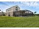 Spacious backyard features lush green grass, large screened-in patio, and in-ground pool with stunning scenery at 8113 Sun Palm Dr, Kissimmee, FL 34747