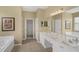 Bathroom featuring double sinks, a large mirror, a bathtub, and a walk-in closet at 8113 Sun Palm Dr, Kissimmee, FL 34747