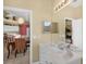 Bathroom featuring a double sink vanity and a view of the dining area at 8113 Sun Palm Dr, Kissimmee, FL 34747