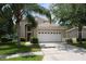 Charming beige two-story home with a well-manicured lawn and a two-car garage at 8113 Sun Palm Dr, Kissimmee, FL 34747