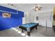 A game room featuring a pool table, a laundry area with a washer and dryer, and bright blue walls at 8113 Sun Palm Dr, Kissimmee, FL 34747