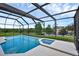 Outdoor pool area with a screen enclosure, a hot tub, and views of the surrounding green landscape at 8113 Sun Palm Dr, Kissimmee, FL 34747
