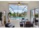 Relaxing screened patio features a ceiling fan, modern furniture, and serene views of the fenced-in community pool at 8113 Sun Palm Dr, Kissimmee, FL 34747