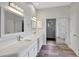 Modern bathroom featuring dual vanities with quartz counters, sleek mirrors, and a glass-enclosed shower at 8623 Summerville Pl, Orlando, FL 32819