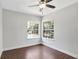 Light and airy bedroom with hardwood floors, ceiling fan, and two large windows at 8623 Summerville Pl, Orlando, FL 32819