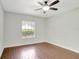Bedroom with wood floors, ceiling fan, and a large window for natural light at 8623 Summerville Pl, Orlando, FL 32819