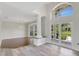 Bright foyer featuring high ceilings, a decorative column, and french doors with natural light at 8623 Summerville Pl, Orlando, FL 32819