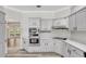 Well-lit kitchen with white cabinets, granite counters, and stainless steel appliances at 8623 Summerville Pl, Orlando, FL 32819