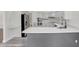 Modern kitchen with white cabinets, stainless appliances, gray island, and quartz countertops at 8623 Summerville Pl, Orlando, FL 32819