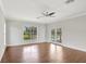 Spacious living room with hardwood flooring, view to the pool, ceiling fan, and glass patio doors at 8623 Summerville Pl, Orlando, FL 32819