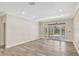 Bright living room featuring wood-look floors, neutral paint, and french doors leading to the patio at 8623 Summerville Pl, Orlando, FL 32819