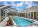 A screened-in pool with a hot tub and well-maintained landscaping accents this backyard at 8623 Summerville Pl, Orlando, FL 32819