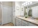 Bathroom featuring double sinks with granite countertop, white cabinets, and a large mirror at 1028 Salamanca Pl, Davenport, FL 33837