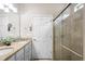 Bright bathroom featuring double sinks with granite countertops and a large glass door shower at 1028 Salamanca Pl, Davenport, FL 33837