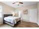 Bedroom with hardwood floors, ceiling fan, and a bed and a door leading to the bathroom at 1028 Salamanca Pl, Davenport, FL 33837