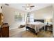 Bedroom with hardwood floors, ceiling fan, and natural light from the two large windows with shades at 1028 Salamanca Pl, Davenport, FL 33837