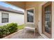 Covered front porch showcasing a decorative bench, stylish front door and well manicured plants at 1028 Salamanca Pl, Davenport, FL 33837